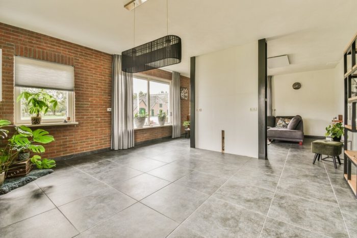 tile flooring. A Living Room With Red Brick Walls And Grey Tile flooring.