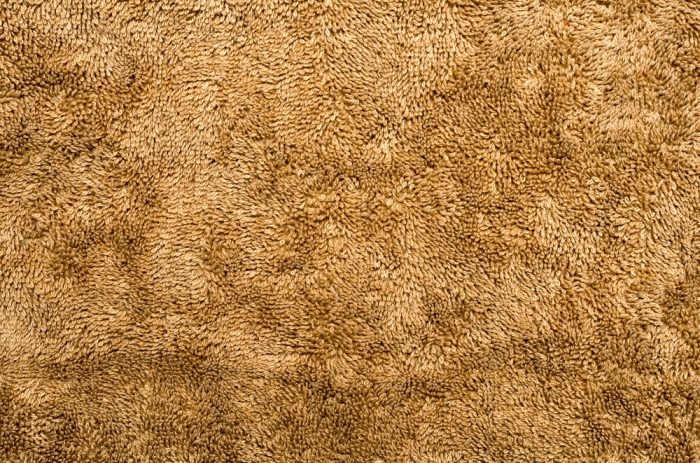 Carpet for Sound Absorption. brown plush fabric close-up - texture.