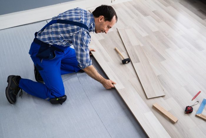 Why Is Ottawa Diamond Flooring a Top Flooring Store in Ottawa? Worker Installing Home Floor. Carpenter Laying Laminate Flooring.